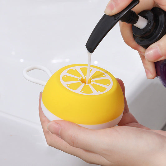 Filling a yellow silicone bath brush with shampoo